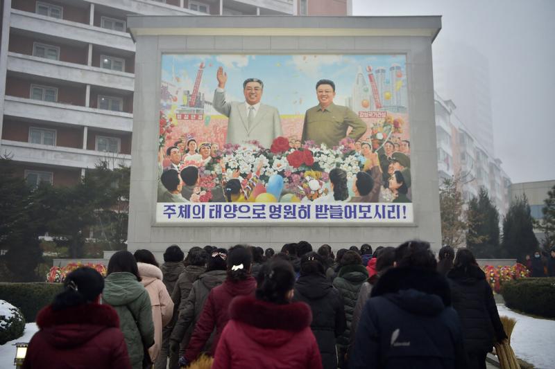 今年早些时候,在平壤,人们在已故朝鲜领导人金日成和金正日的马赛克画像前表示敬意。