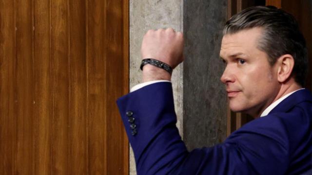 皮特·赫格塞斯 (Pete Hegseth) 举起拳头,望向左侧。