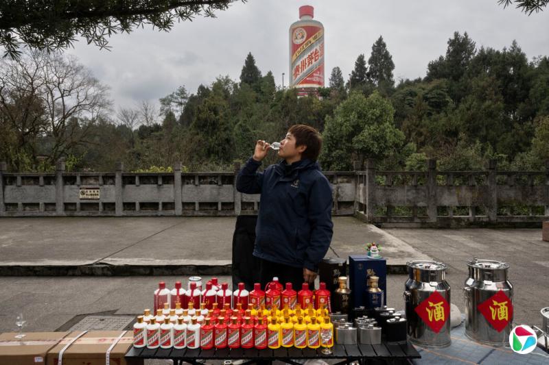袁媛在公园外推广黔醉酒业的白酒,小山上矗立着巨型瓶装的贵州茅台。