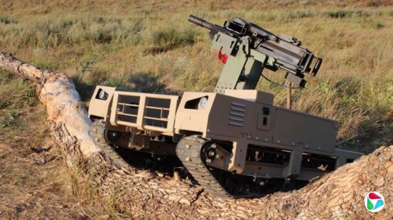 武装无人地面载具(UGV)一个草地上正跨过一根倒塌的树