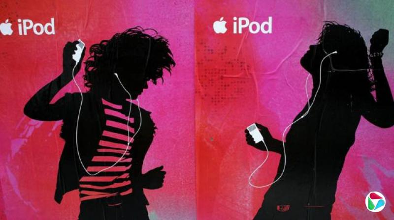 加州旧金山某大楼外张贴着的一组 iPod 海报,画面中两个黑色剪影伴着白色iPod(附白色有线耳机)在粉红色背景前翩翩起舞。苹果标志和“iPod”字样也出现在画面中。(2006年5月)