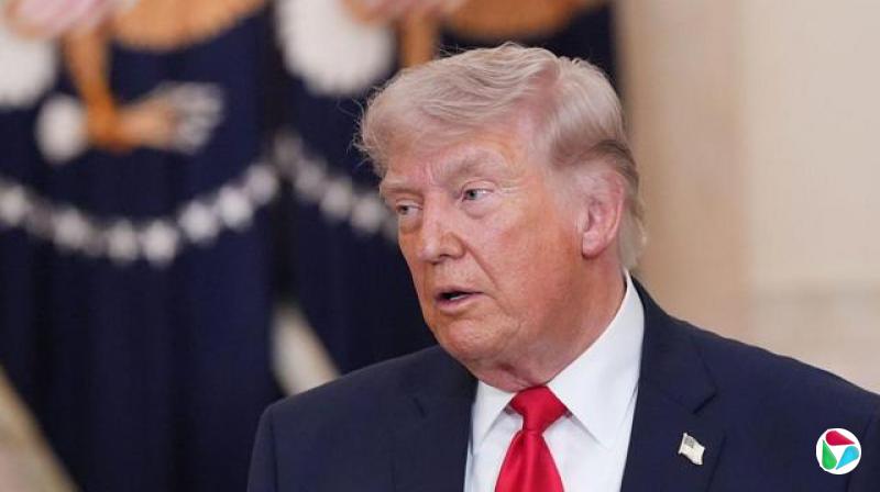 美国总统唐纳?特朗普身穿深色西装、白衬衫与红色领带,在室内站在一面印有美国总统徽章的旗帜前发言。