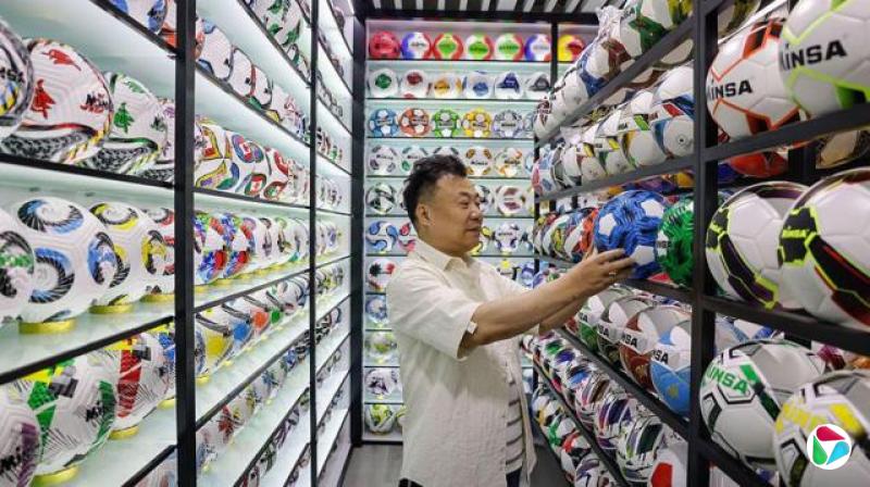 中国浙江省义乌市,一名摊商于义乌国际商贸城检查足球相关商品