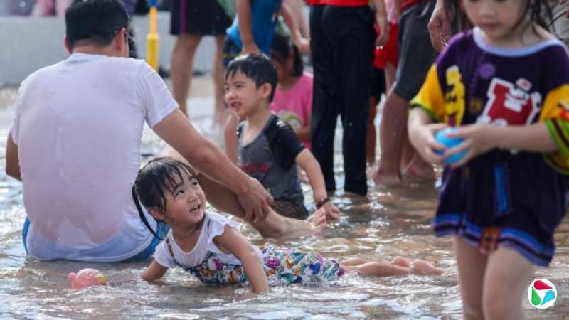 台湾家长陪同小孩在酷热天气中玩耍
