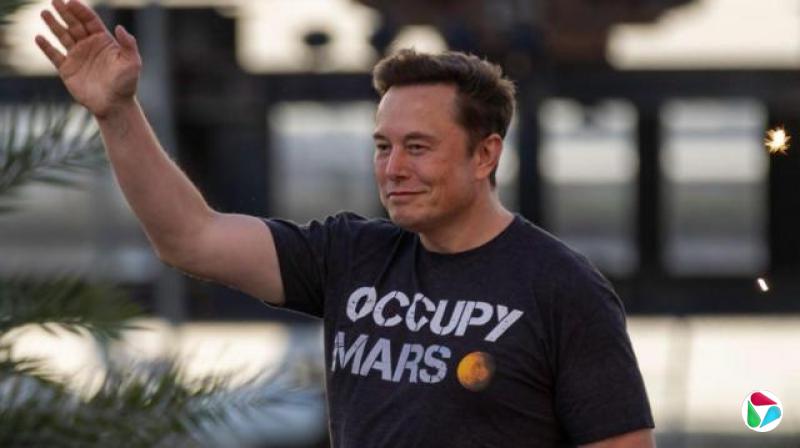 马斯克身穿印有“占领火星”(Occupy Mars)字样的上衣,在舞台上行走