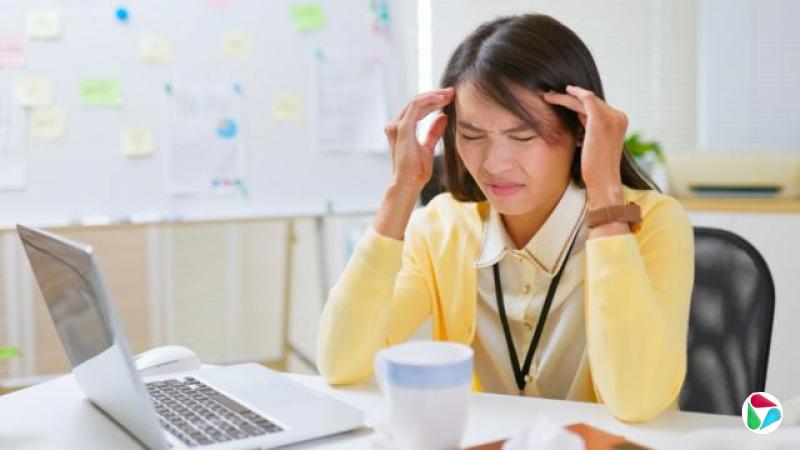 设计图片:在台湾,一位女士坐在办公桌前,表情看似头疼不堪,状甚痛苦