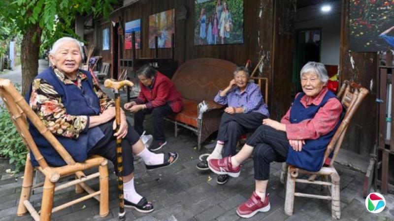 四川成都双流区彭镇,几位老太太坐在一家社区画廊门前摆放着的椅子上聊天(中新社图片28/9/2026)